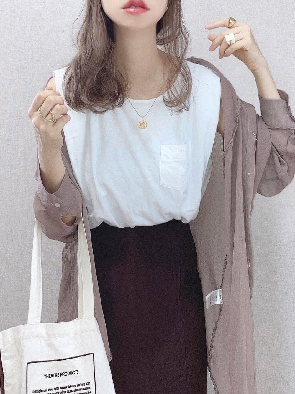 ブラウン系のスカート、ホワイト系のTシャツ/カットソー、ベージュ系のシャツ/ブラウスを着用したレディースの夏コーディネートの2枚目の写真