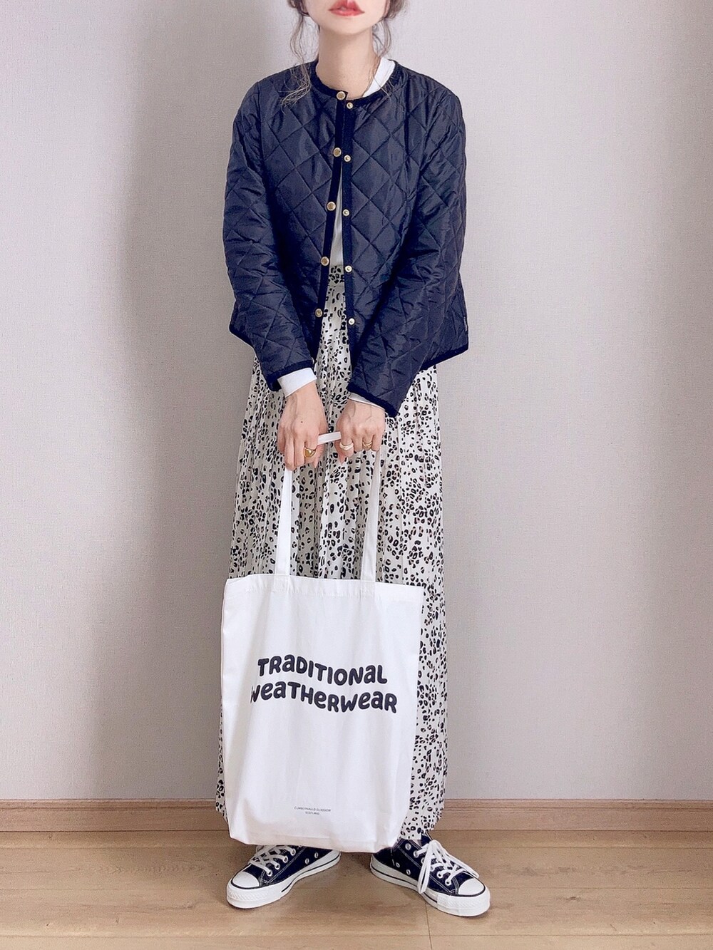 ブラック系のノーカラージャケット、ホワイト系のトートバッグ、ホワイト系のスカートを着用したレディースの秋コーディネートの2枚目の写真