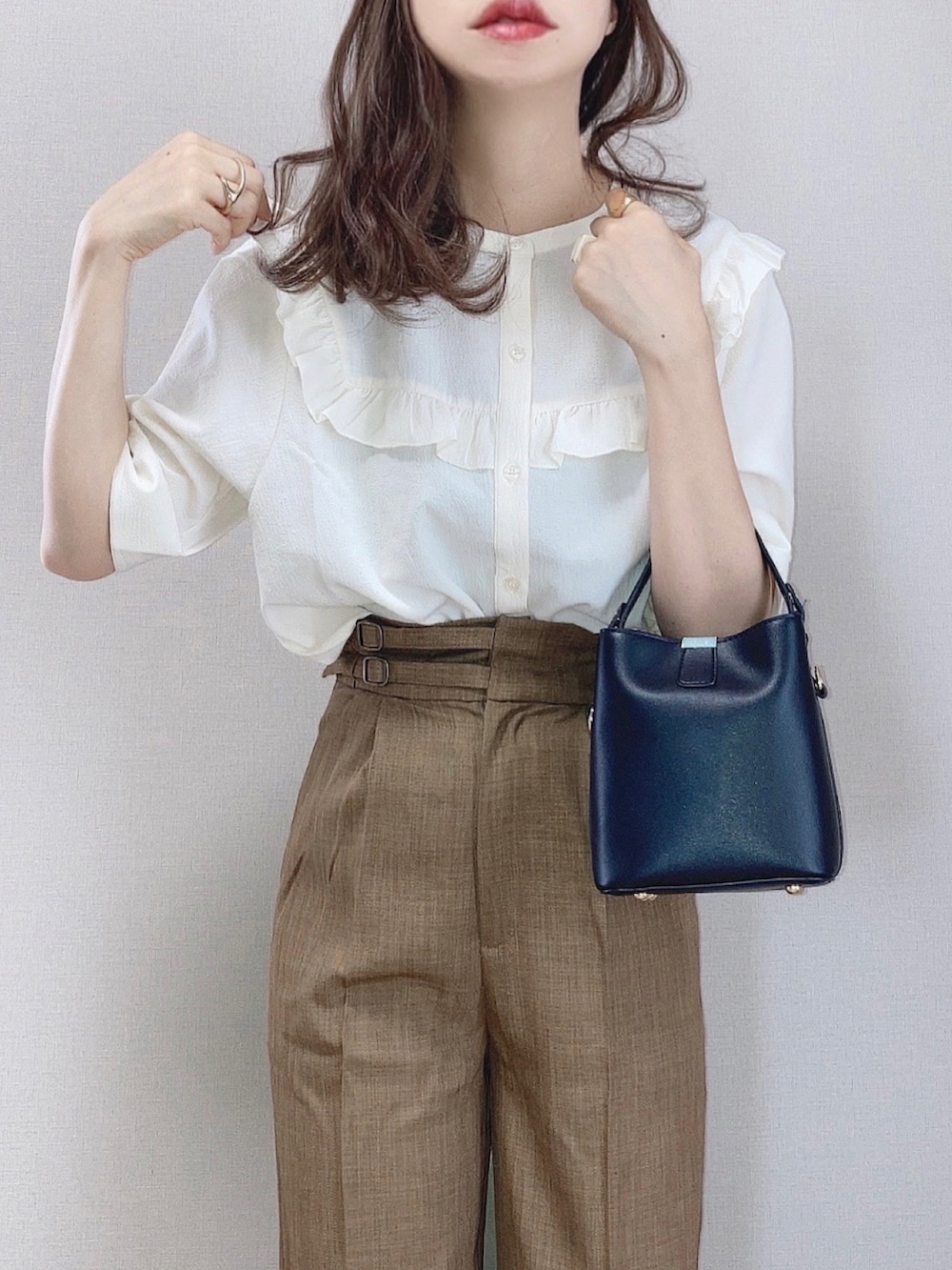 ベージュ系のシャツ/ブラウス、ブラウン系のスラックス、ホワイト系のシャツ/ブラウスを着用したレディースの夏コーディネートの2枚目の写真