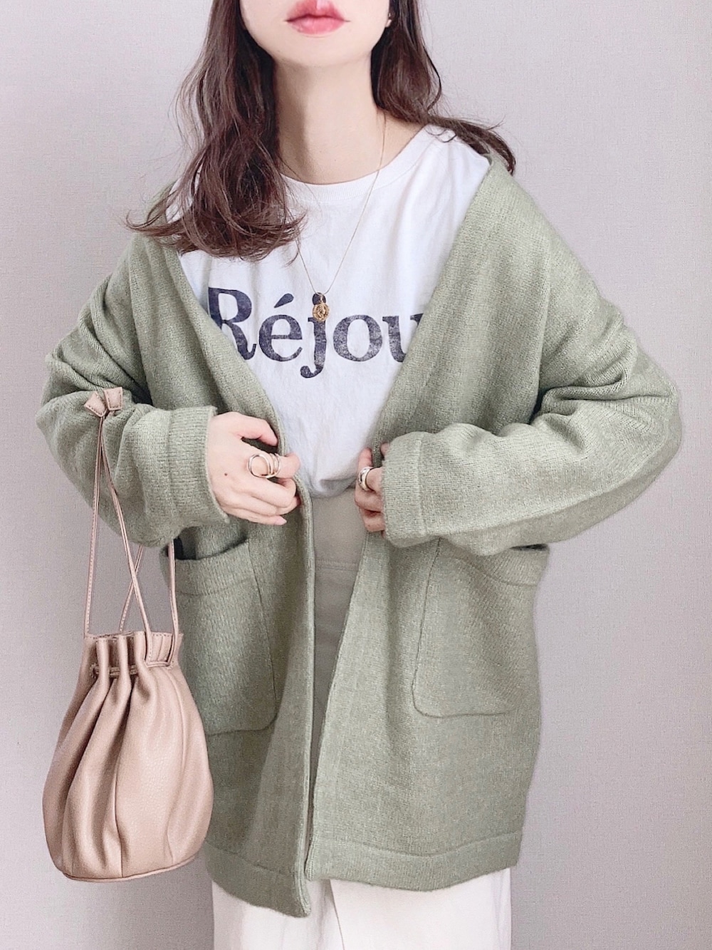 グリーン系のカーディガン/ボレロ、ホワイト系のTシャツ/カットソー、ホワイト系のスカートを着用したレディースの冬コーディネートの2枚目の写真