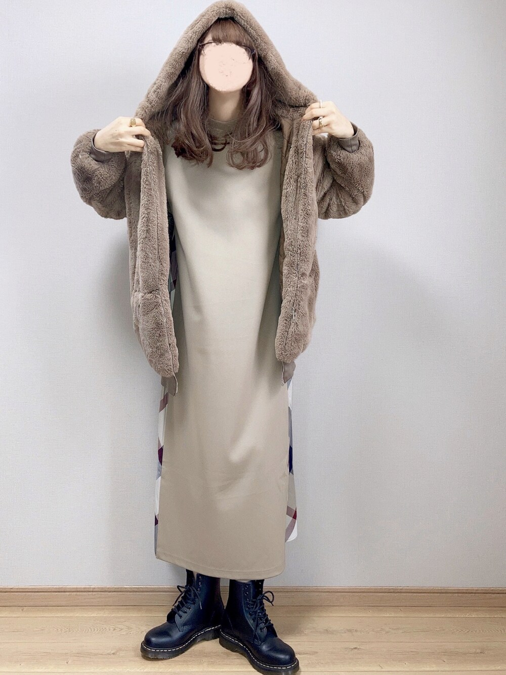 ベージュ系のワンピース、ブラウン系のブルゾン、ブラック系のブーツを着用したレディースの冬コーディネートの3枚目の写真