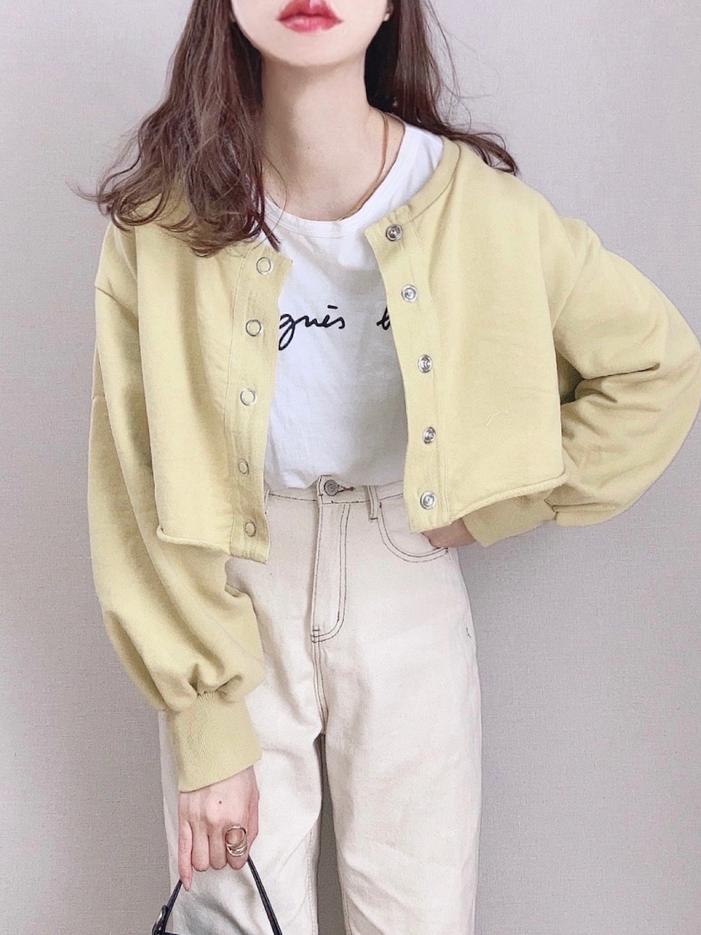 イエロー系のスウェット、ホワイト系のTシャツ/カットソー、ブラック系のショルダーバッグを着用したレディースの春コーディネートの2枚目の写真