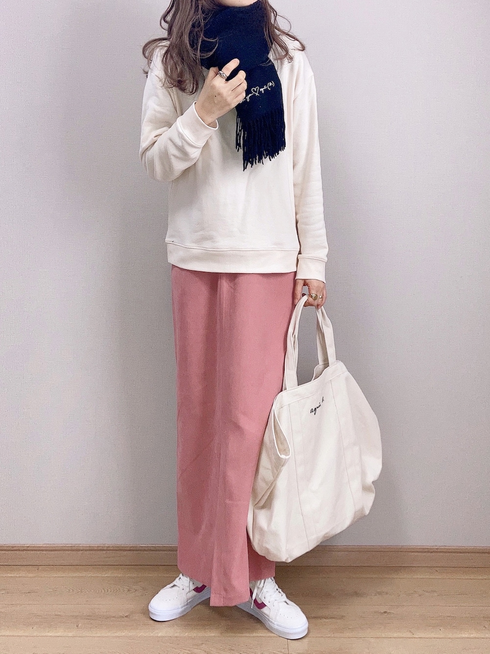 ホワイト系のスウェット、ホワイト系のトートバッグ、ピンク系のスカートを着用したレディースの冬コーディネートの2枚目の写真