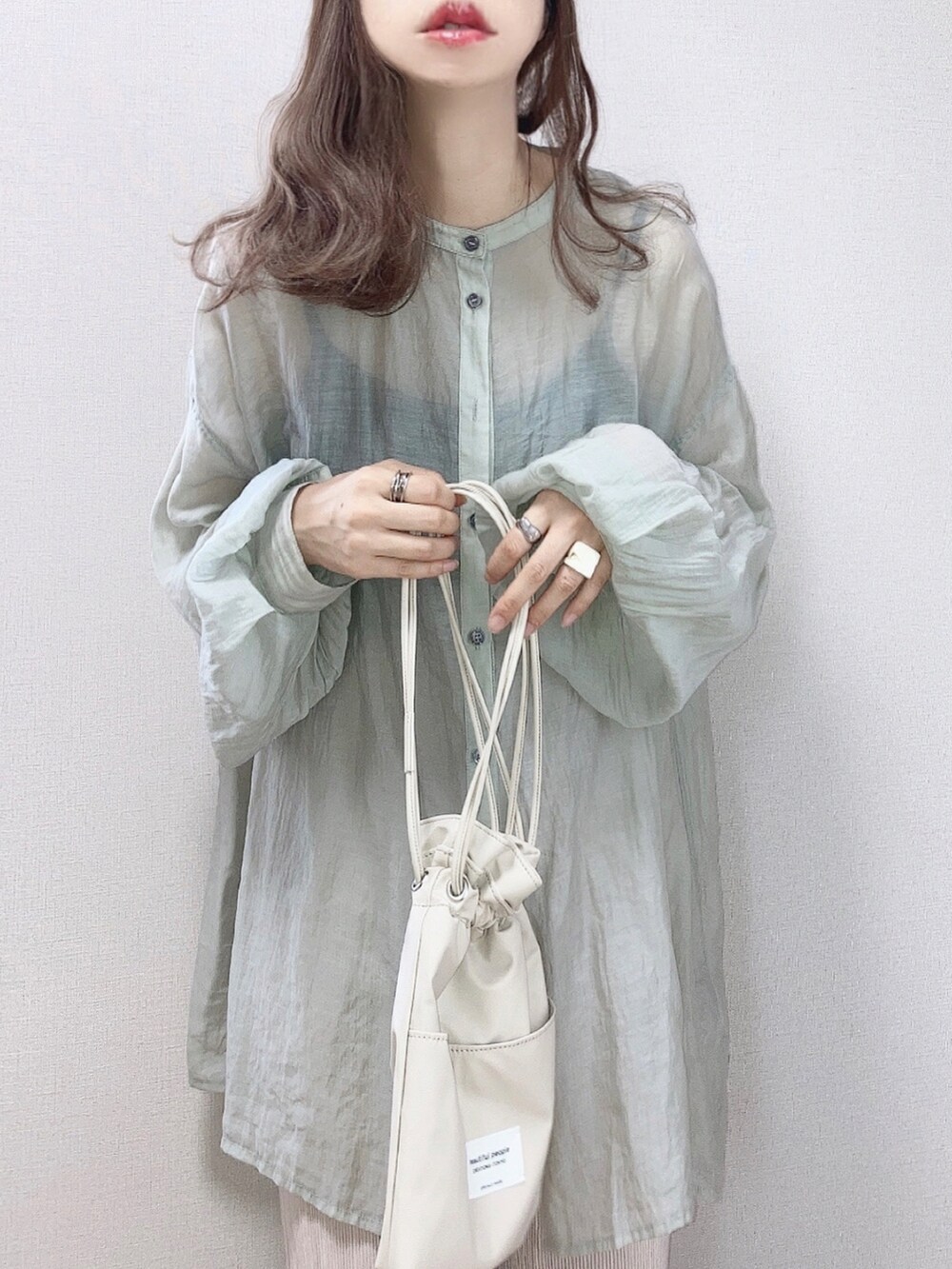 グリーン系のシャツ/ブラウス、ベージュ系のショルダーバッグ、グレー系のサンダルを着用したレディースの夏コーディネートの2枚目の写真