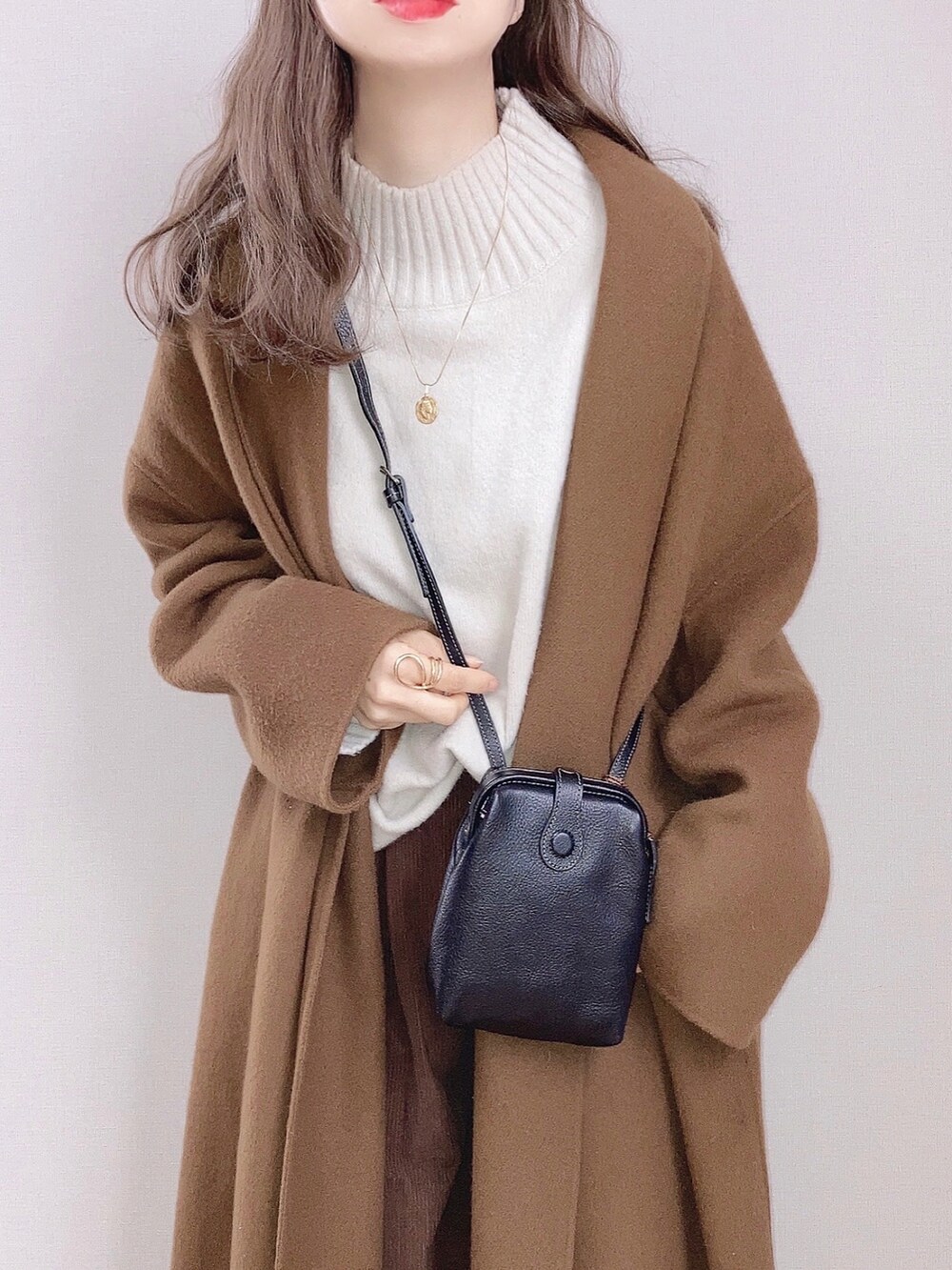 ブラック系のショルダーバッグ、イエロー系のダウンジャケット/コート、ブラウン系のその他パンツを着用したレディースの冬コーディネートの2枚目の写真