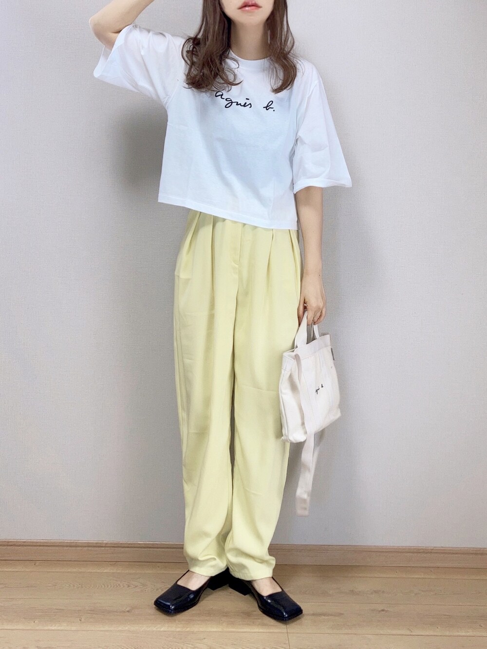 ホワイト系のTシャツ/カットソー、ホワイト系のトートバッグ、イエロー系のスラックスを着用したレディースの春コーディネートの3枚目の写真