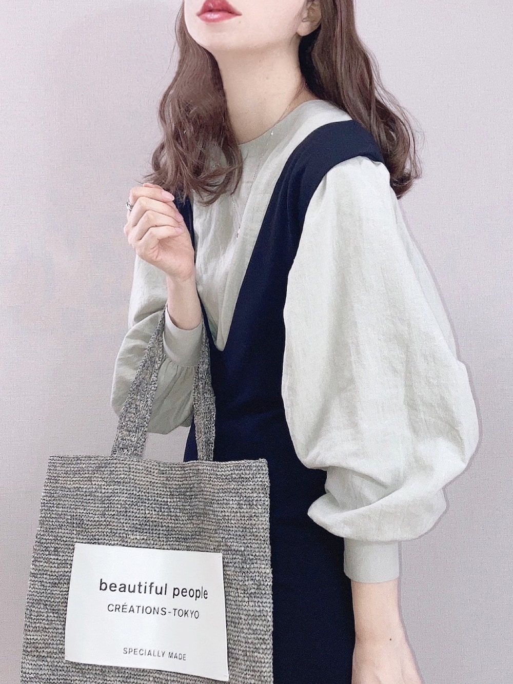 ブラック系のワンピース、グリーン系のシャツ/ブラウス、グレー系のトートバッグを着用したレディースの春コーディネートの2枚目の写真