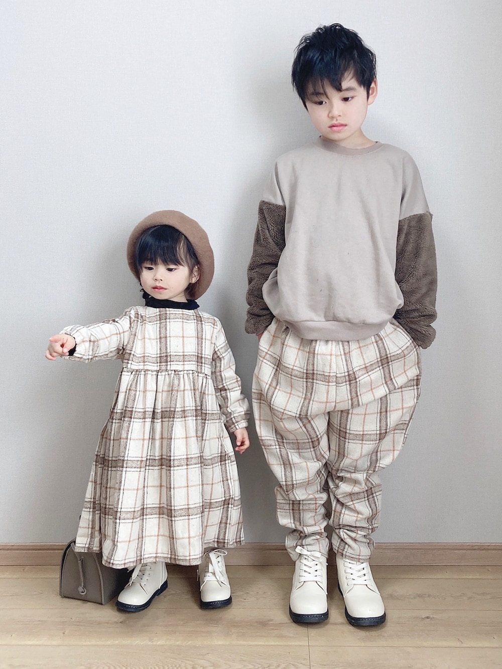ベージュ系のワンピース、ホワイト系のブーツ、ベージュ系のスウェットを着用したキッズの冬コーディネートの2枚目の写真
