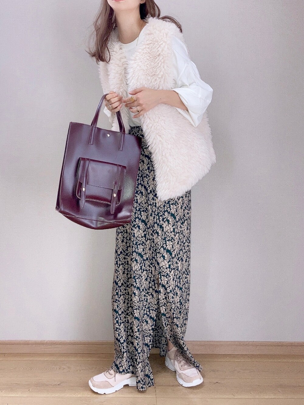 ホワイト系のベスト、ホワイト系のTシャツ/カットソー、グリーン系のスカートを着用したレディースの秋コーディネートの2枚目の写真