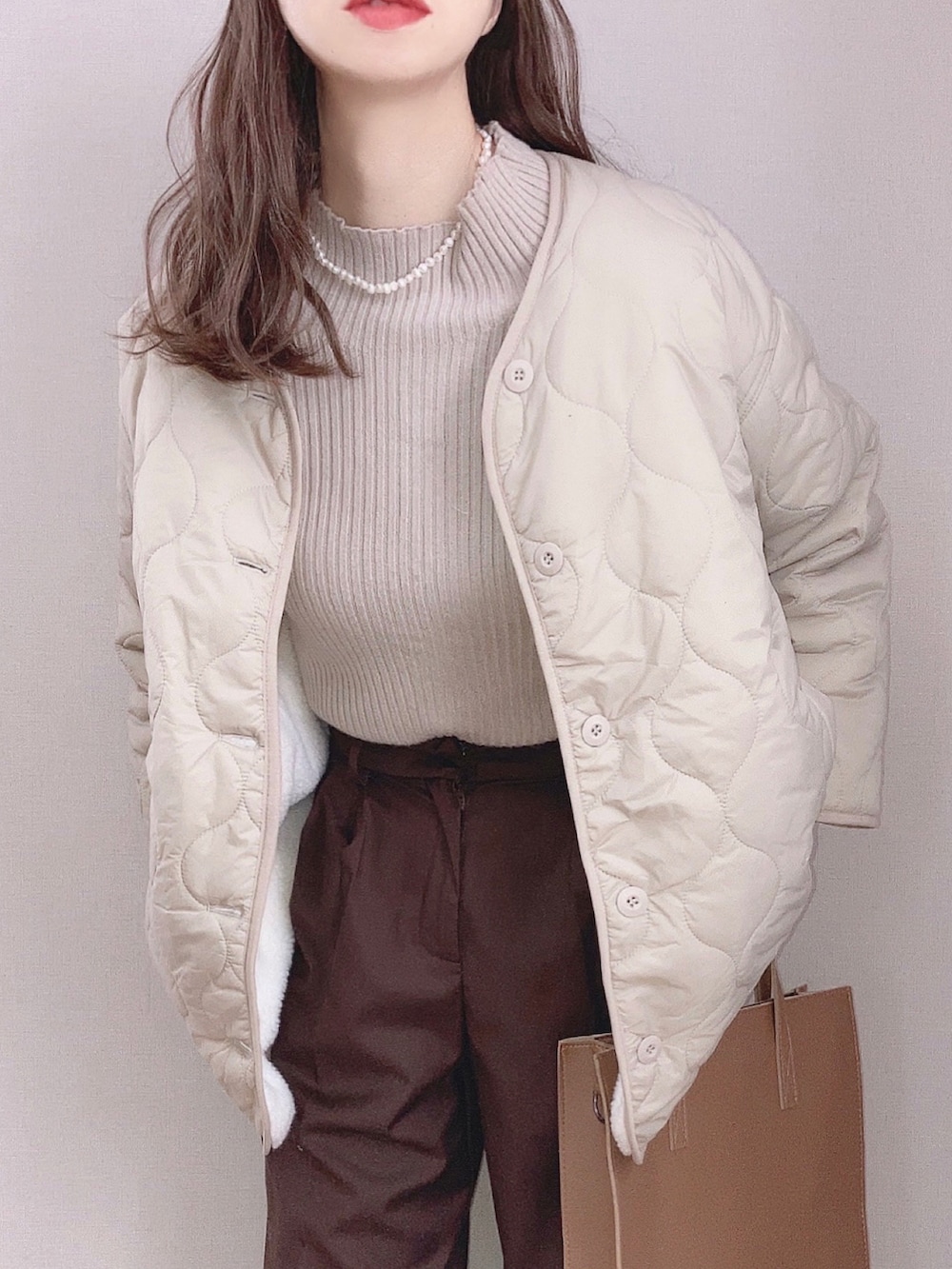 ベージュ系のブルゾン、ブラウン系のニット/セーター、ブラウン系のスラックスを着用したレディースの秋コーディネートの3枚目の写真