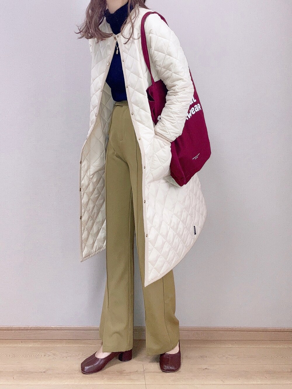 ホワイト系のその他アウター、グリーン系のスラックス、レッド系のトートバッグを着用したレディースの秋コーディネートの2枚目の写真