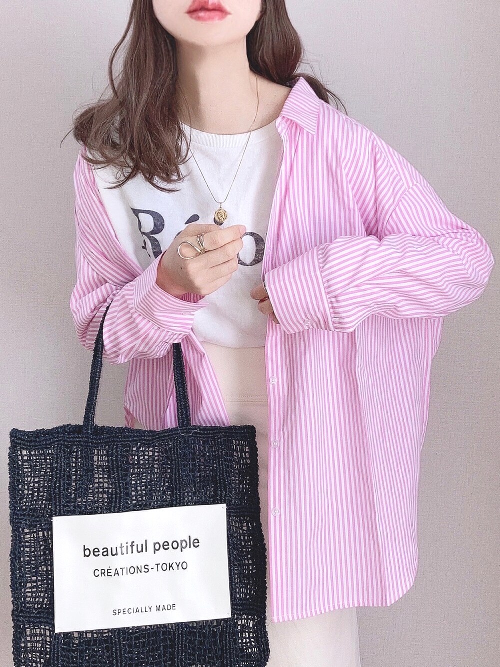 ピンク系のシャツ/ブラウス、ホワイト系のTシャツ/カットソー、ホワイト系のスカートを着用したレディースの春コーディネートの2枚目の写真