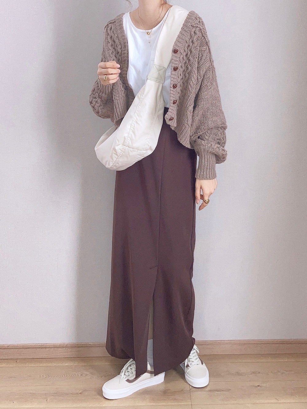 ブラウン系のカーディガン/ボレロ、ブラウン系のスカート、ホワイト系のショルダーバッグを着用したレディースの秋コーディネートの3枚目の写真
