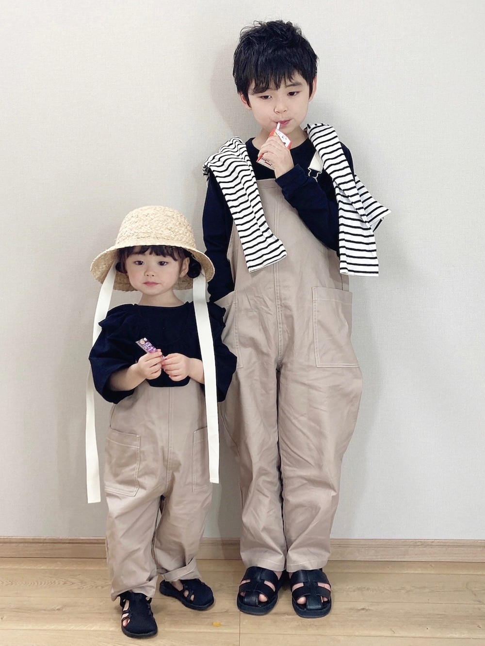 ベージュ系のサロペット/オーバーオール、ブラック系のTシャツ/カットソー、ブラック系のTシャツ/カットソーを着用したキッズの春コーディネートの3枚目の写真