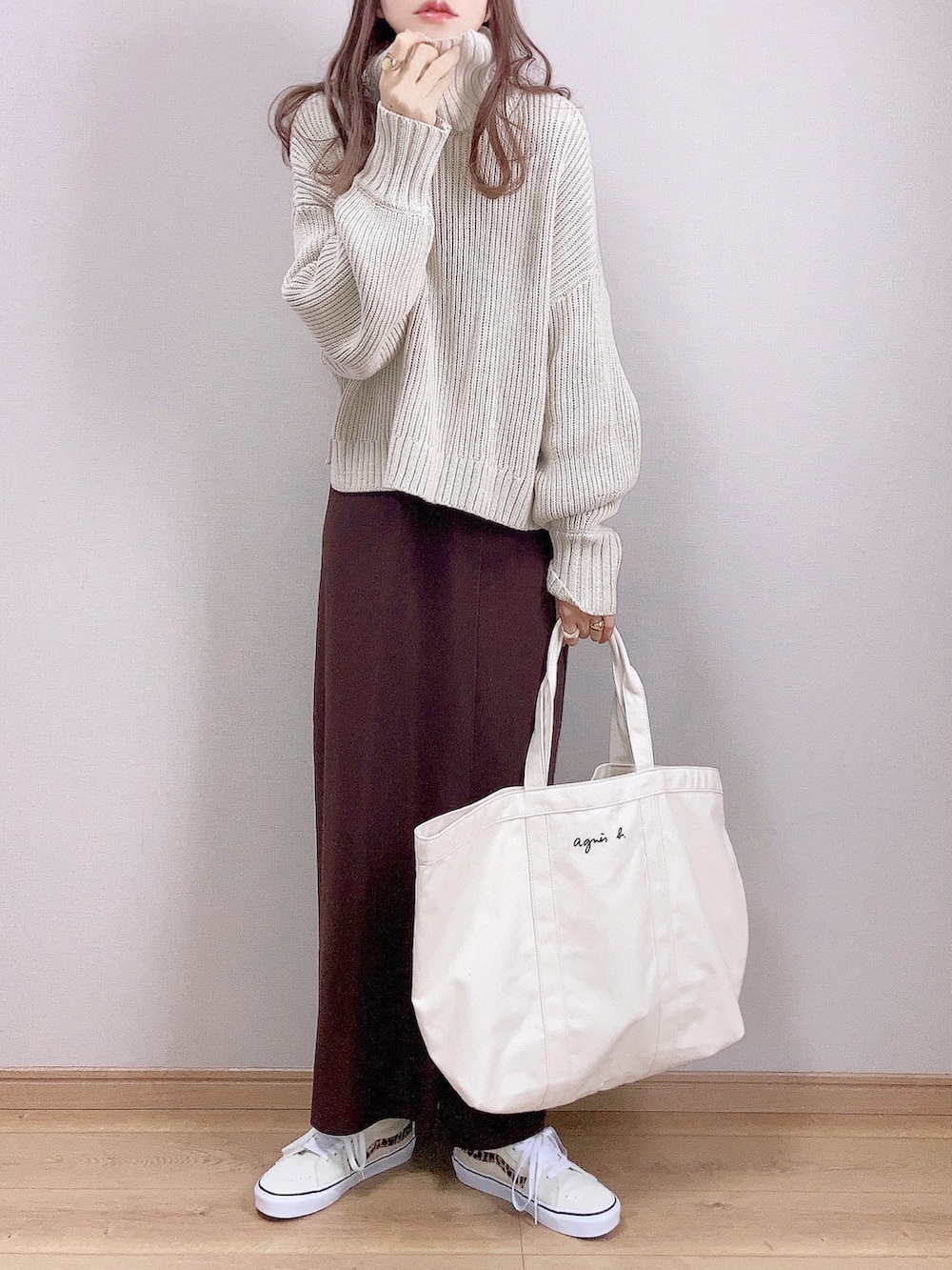 ベージュ系のニット/セーター、ブラウン系のスカート、ホワイト系のトートバッグを着用したレディースの秋コーディネートの2枚目の写真
