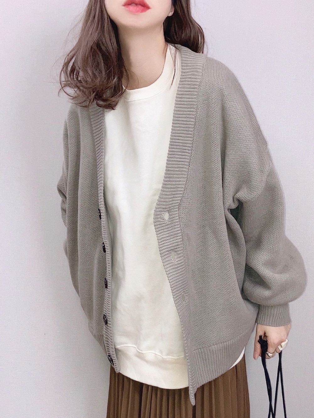 ベージュ系のカーディガン/ボレロ、ホワイト系のスウェット、ブラウン系のスカートを着用したレディースの冬コーディネートの2枚目の写真