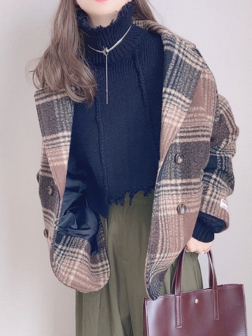 ブラウン系のテーラードジャケット、ブラック系のニット/セーター、グリーン系のその他パンツを着用したレディースの秋コーディネートの2枚目の写真