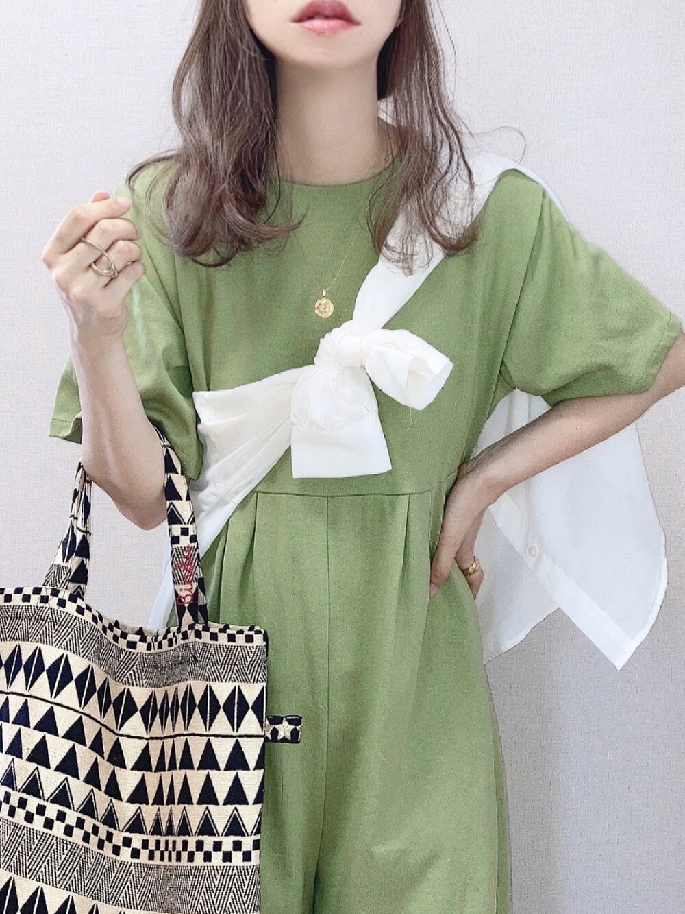 グリーン系のサロペット/オーバーオール、ホワイト系のシャツ/ブラウス、ブラック系のショルダーバッグを着用したレディースの夏コーディネートの2枚目の写真