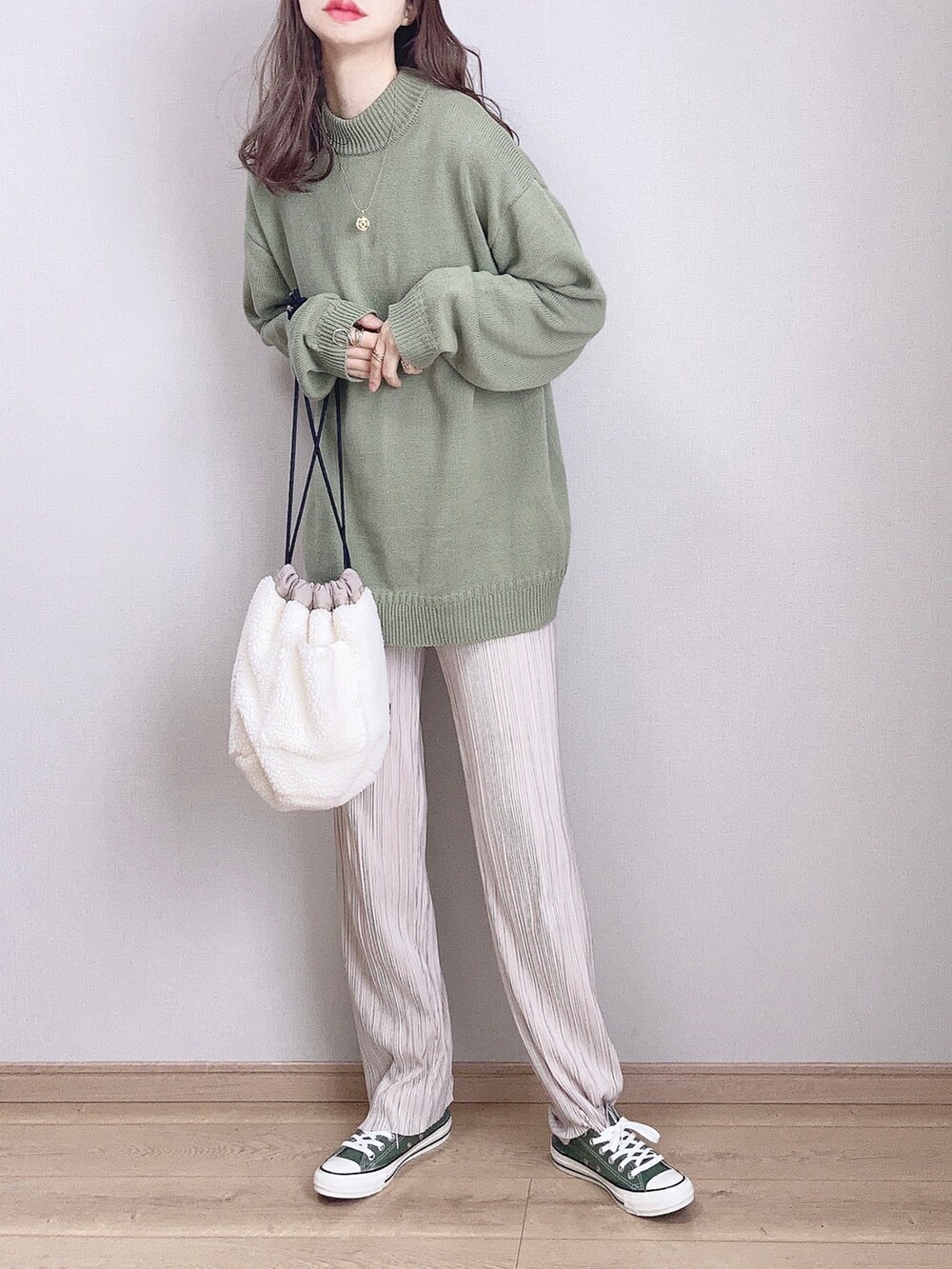 ホワイト系のピーコート、グリーン系のニット/セーター、グリーン系のスニーカーを着用したレディースの冬コーディネートの2枚目の写真