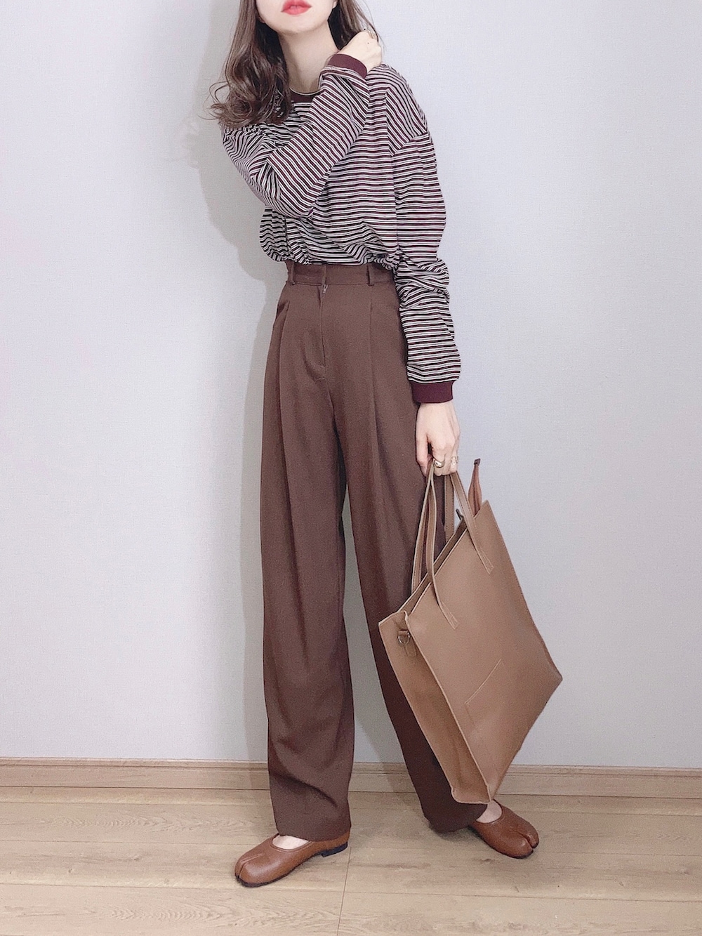 ブラウン系のTシャツ/カットソー、ホワイト系のカーディガン/ボレロ、ブラウン系のその他パンツを着用したレディースの冬コーディネートの3枚目の写真