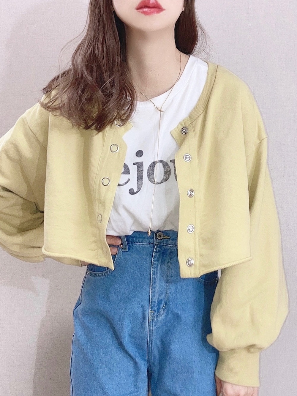 イエロー系のスウェット、ホワイト系のTシャツ/カットソー、ブルー系のデニムパンツを着用したレディースの春コーディネートの2枚目の写真