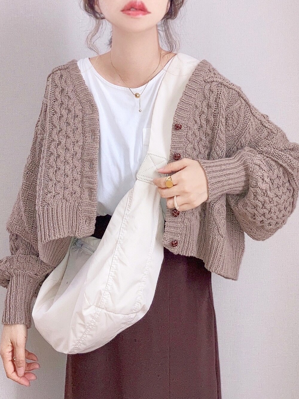 ブラウン系のカーディガン/ボレロ、ブラウン系のスカート、ホワイト系のショルダーバッグを着用したレディースの秋コーディネートの4枚目の写真