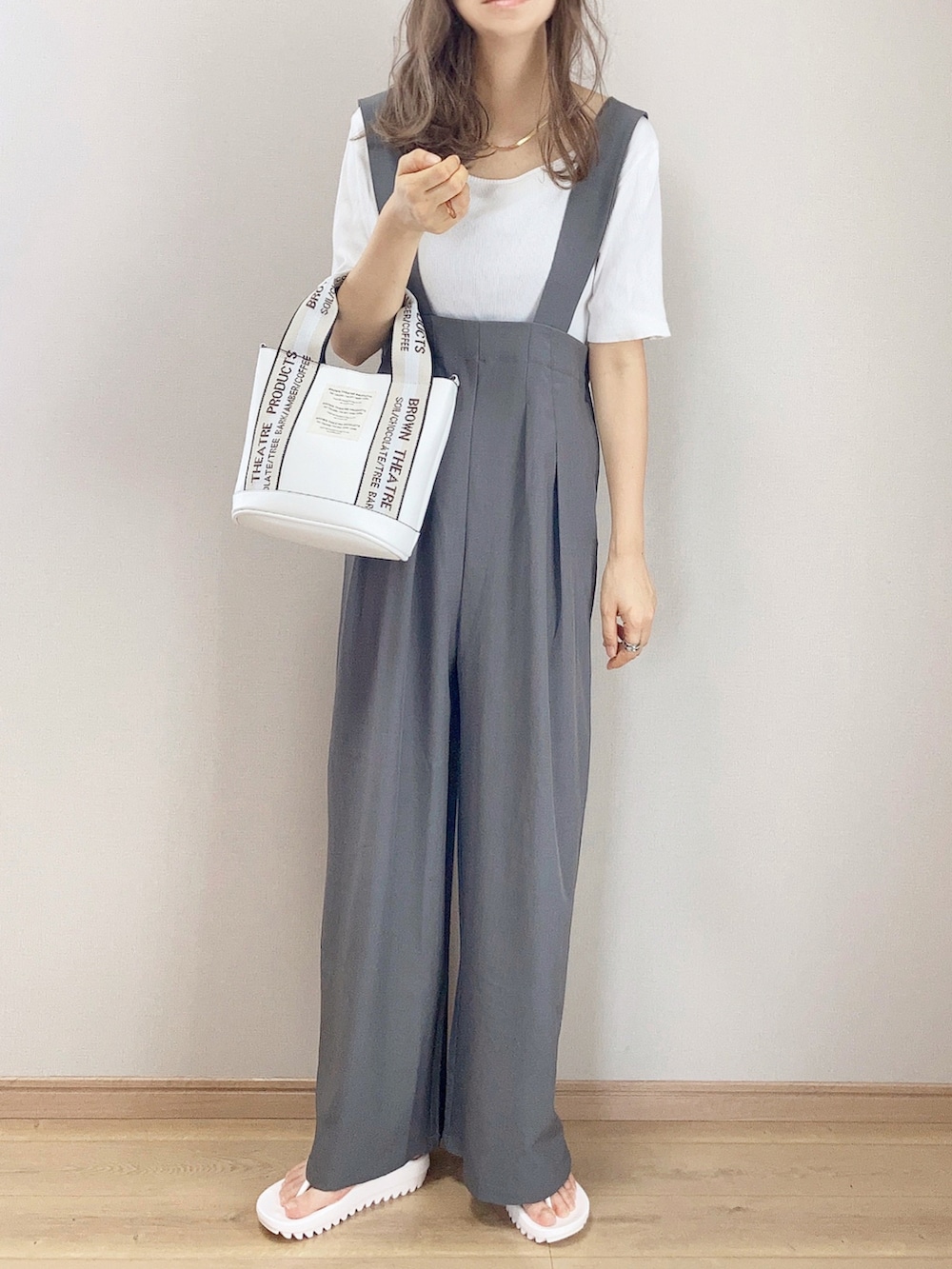 ホワイト系のショルダーバッグ、ベージュ系のサンダル、グレー系のサロペット/オーバーオールを着用したレディースの夏コーディネートの2枚目の写真