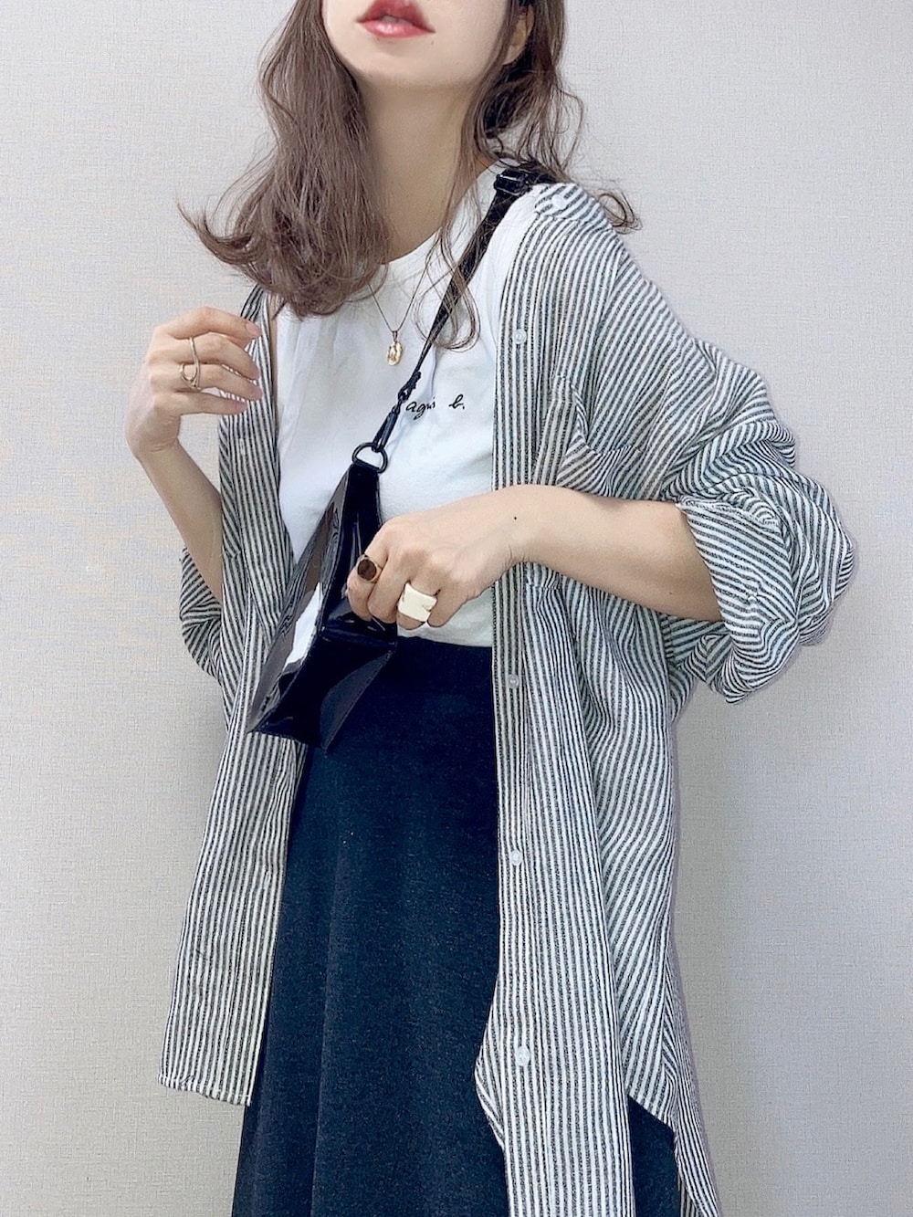 ブラック系のスカート、ブラック系のシャツ/ブラウス、ホワイト系のTシャツ/カットソーを着用したレディースの夏コーディネートの2枚目の写真