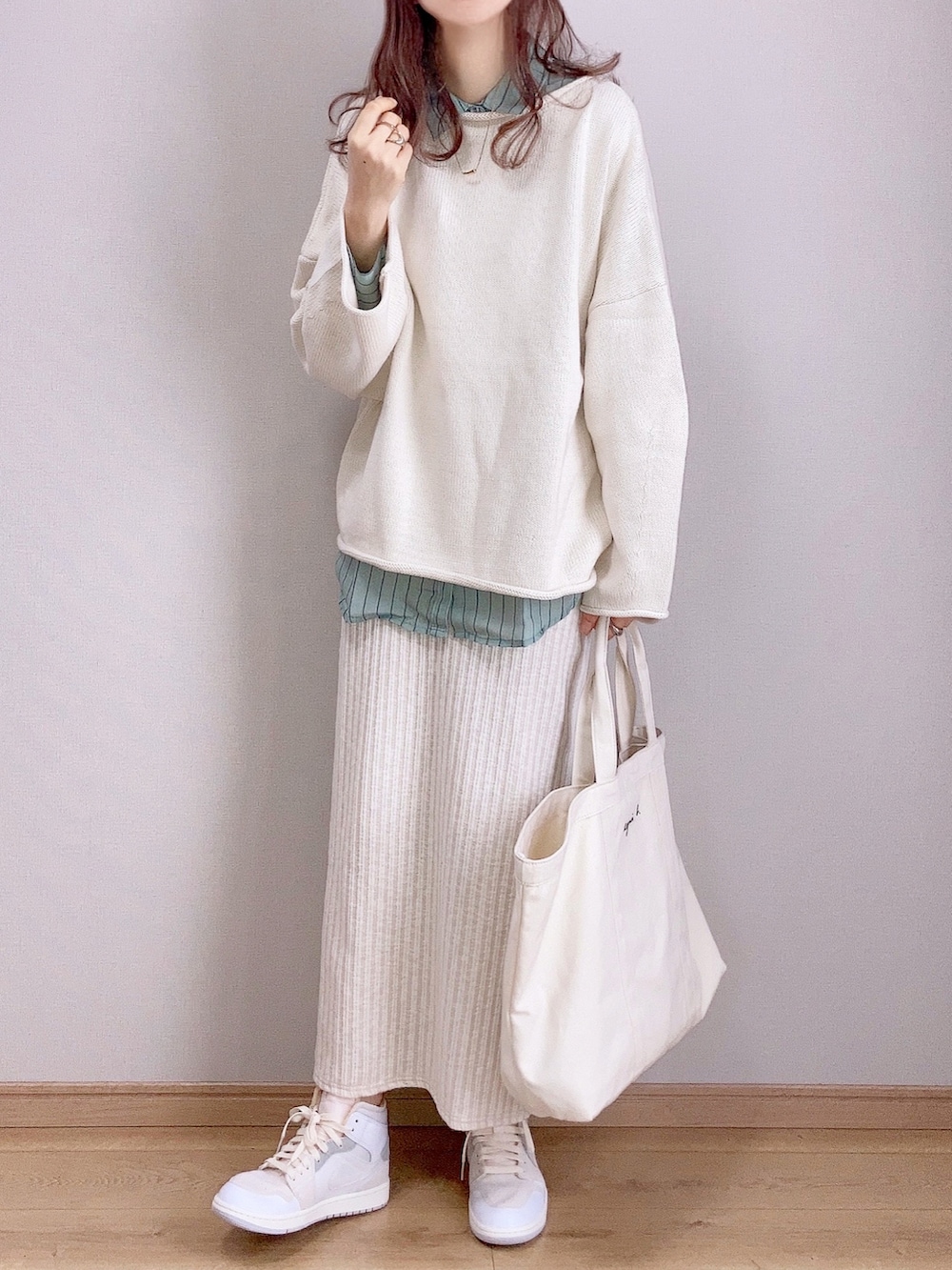 ホワイト系のスカート、ホワイト系のニット/セーター、グリーン系のシャツ/ブラウスを着用したレディースの冬コーディネートの3枚目の写真