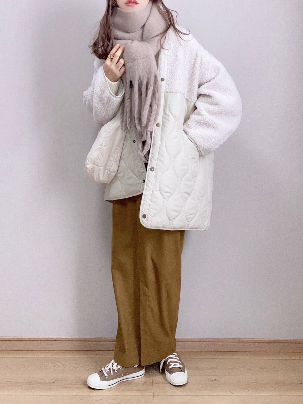 ホワイト系のブルゾン、グリーン系のニット/セーター、ブラウン系のスカートを着用したレディースの冬コーディネートの2枚目の写真