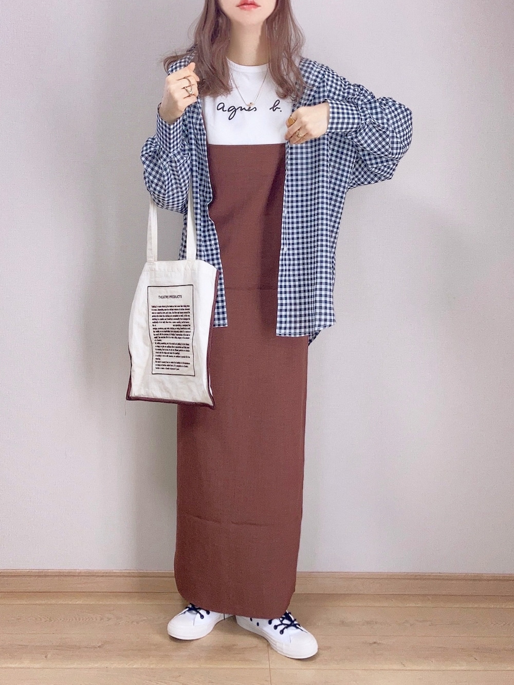 ブラック系のシャツ/ブラウス、ブラウン系のワンピース、ベージュ系のトートバッグを着用したレディースの春コーディネートの2枚目の写真