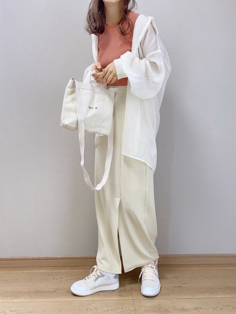 オレンジ系のTシャツ/カットソー、ホワイト系のシャツ/ブラウス、ホワイト系のスカートを着用したレディースの夏コーディネートの2枚目の写真