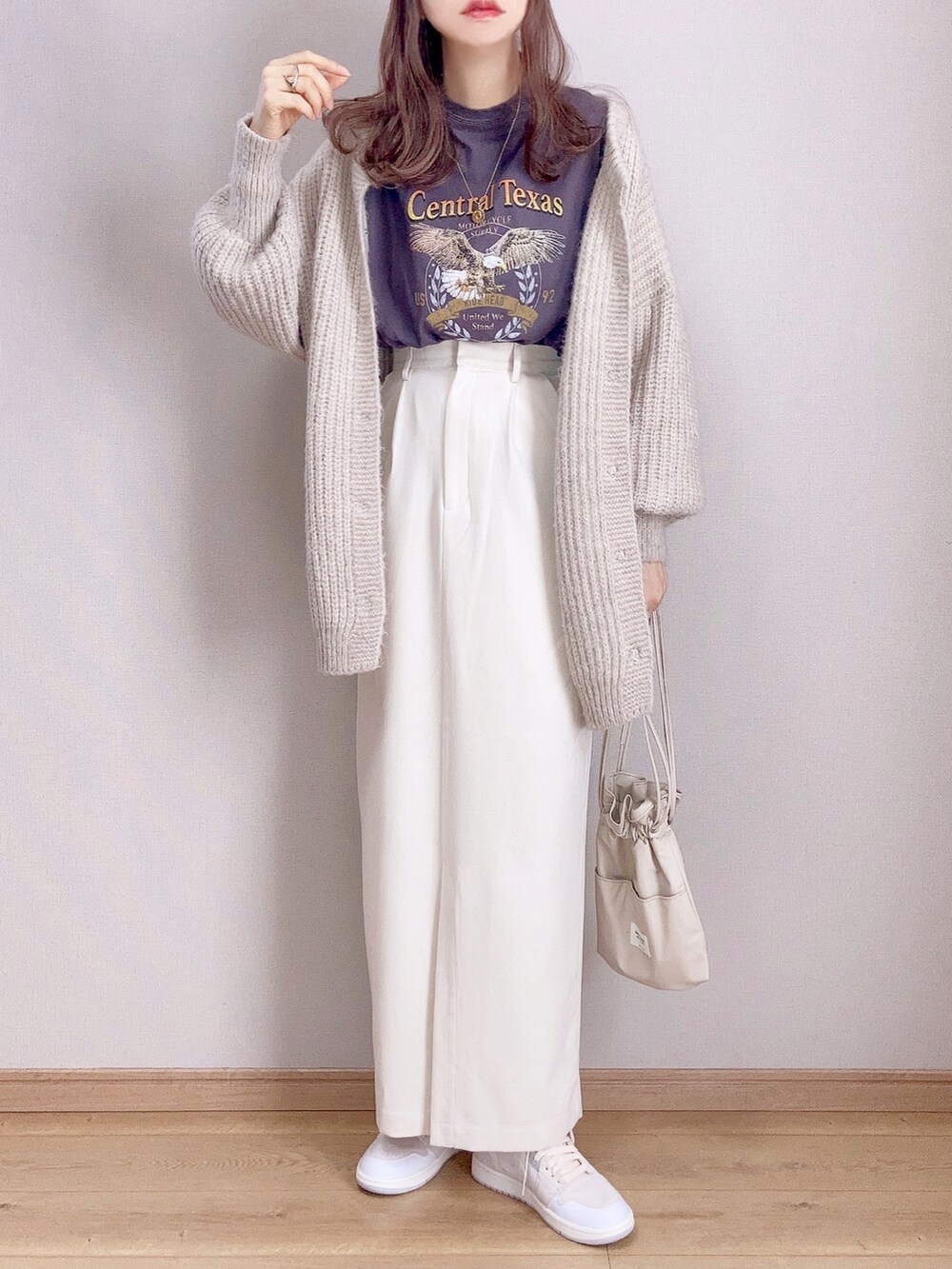 ブラック系のTシャツ/カットソー、ホワイト系のカーディガン/ボレロ、ホワイト系のスカートを着用したレディースの冬コーディネートの2枚目の写真