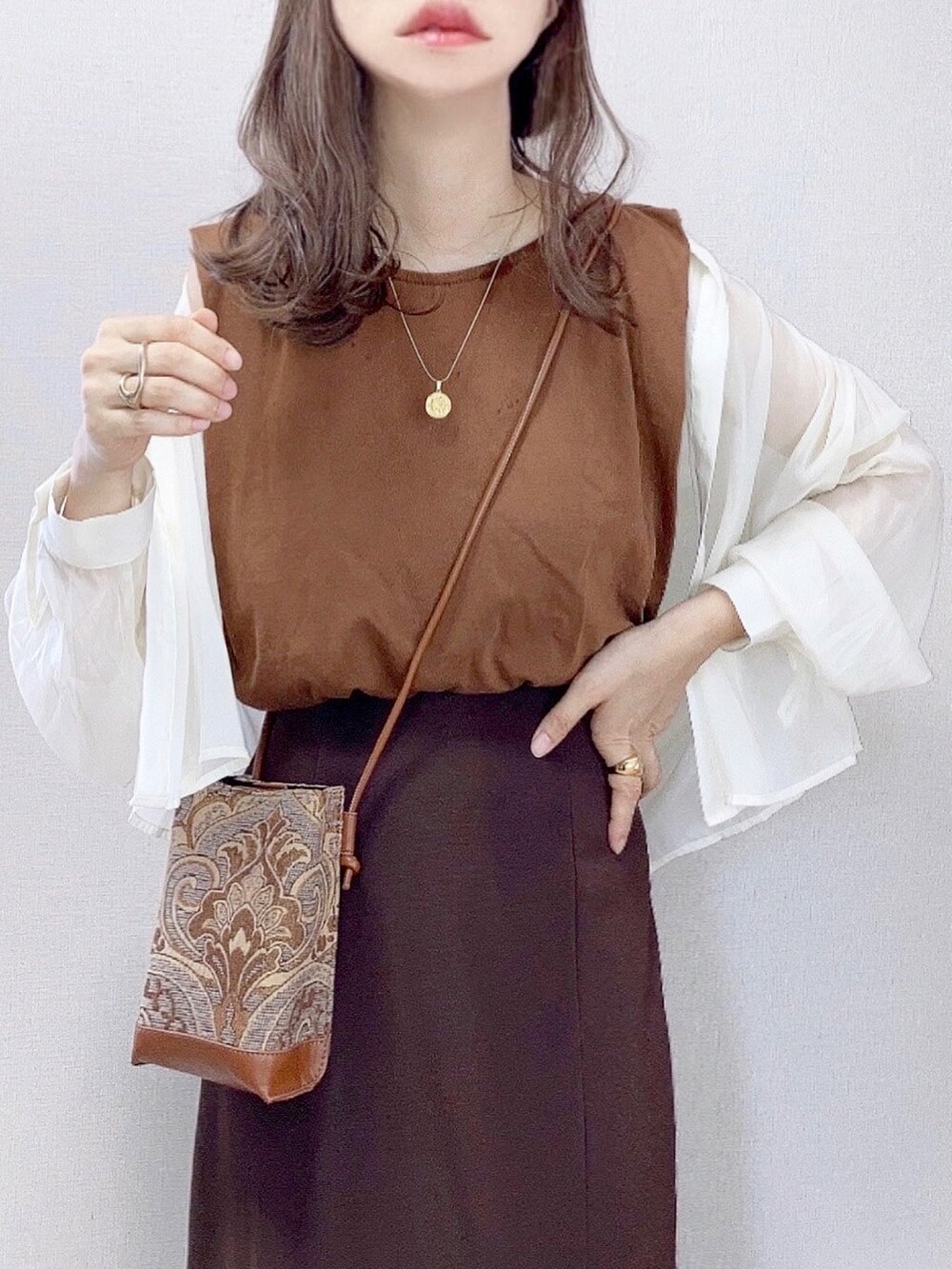 ベージュ系のシャツ/ブラウス、ブラウン系のタンクトップ、ブラウン系のスカートを着用したレディースの夏コーディネートの2枚目の写真