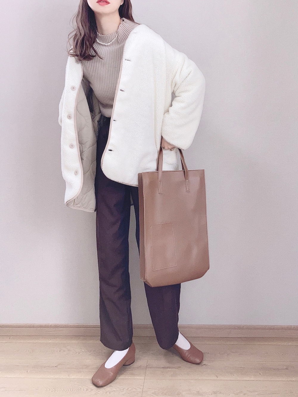 ベージュ系のブルゾン、ブラウン系のニット/セーター、ブラウン系のスラックスを着用したレディースの秋コーディネートの2枚目の写真