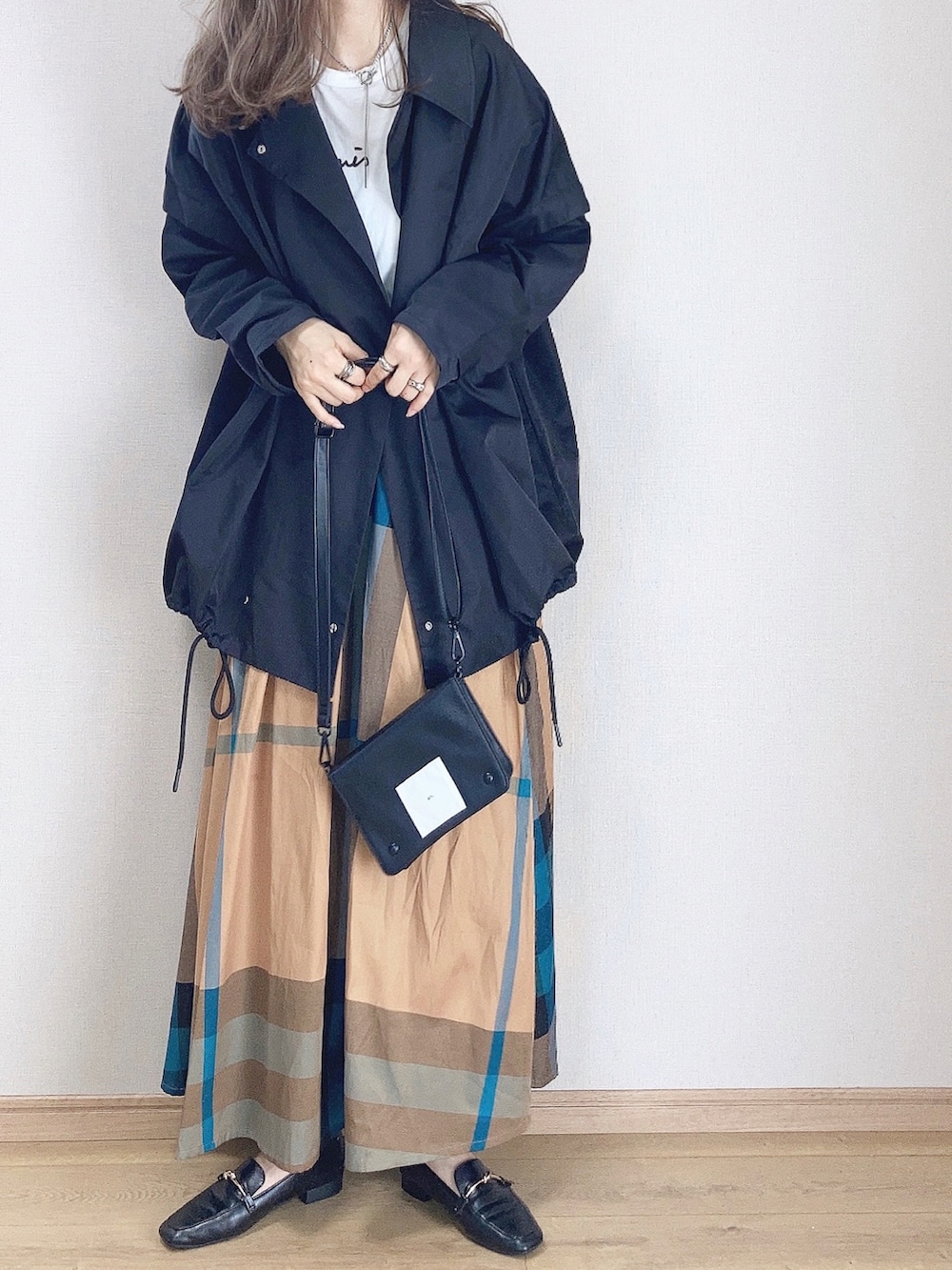 ブラック系のその他アウター、イエロー系のスカート、ブラック系のショルダーバッグを着用したレディースの秋コーディネートの3枚目の写真