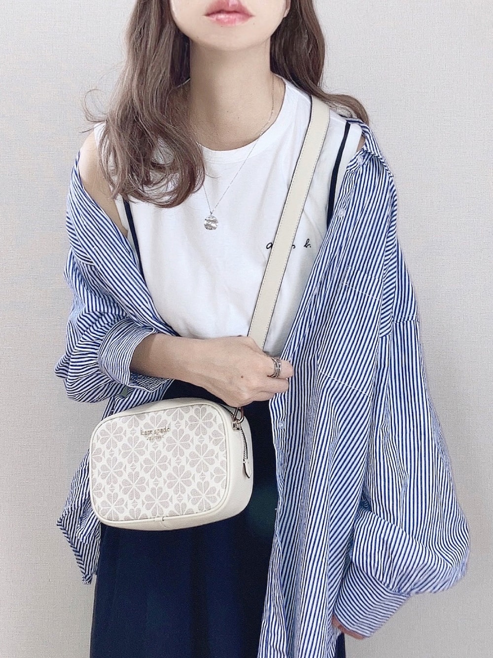 ホワイト系のショルダーバッグ、ホワイト系のTシャツ/カットソー、ブルー系のシャツ/ブラウスを着用したレディースの春コーディネートの2枚目の写真