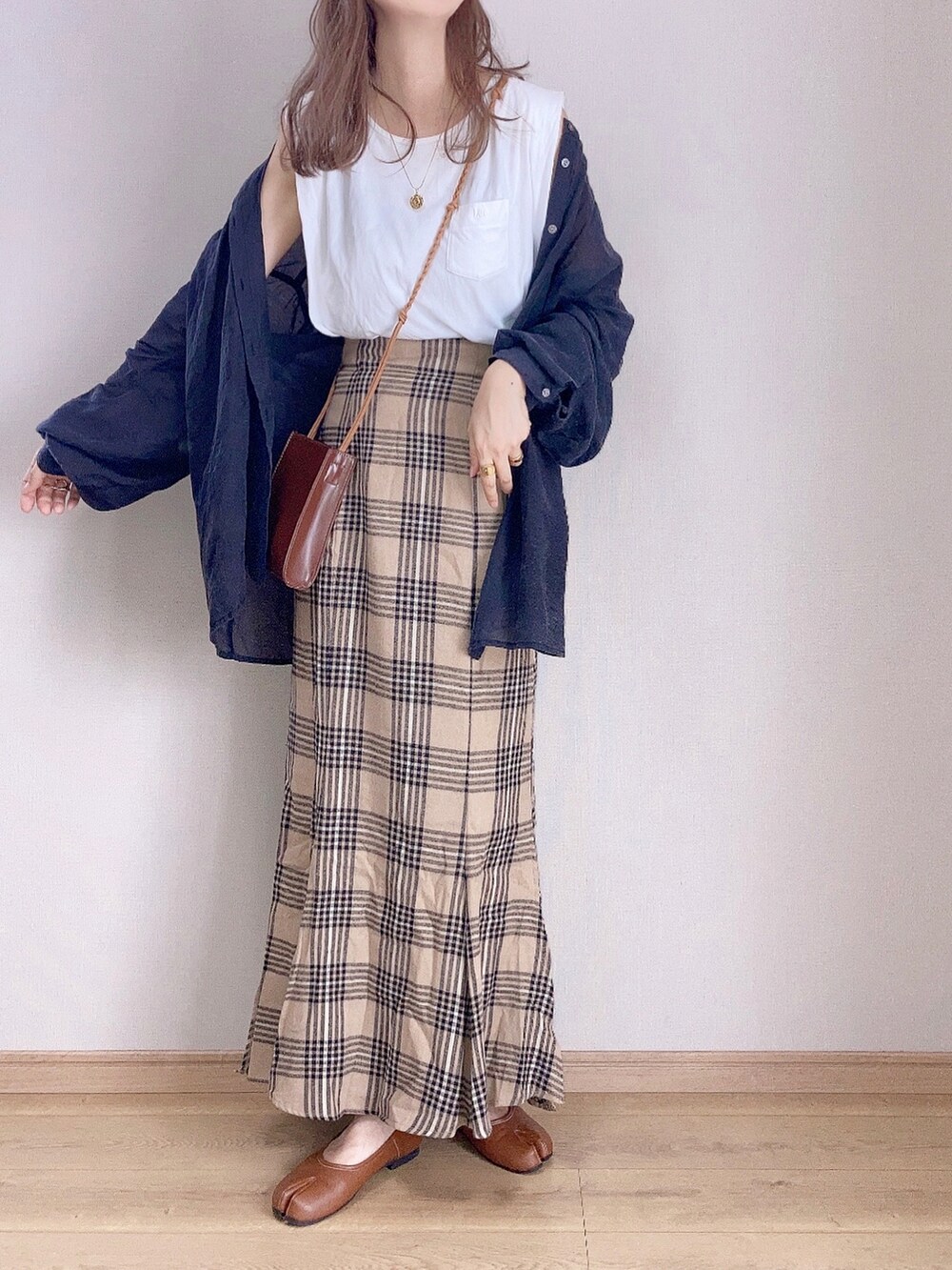 ブラウン系のスカート、ブラック系のシャツ/ブラウス、ブラウン系のショルダーバッグを着用したレディースの秋コーディネートの3枚目の写真