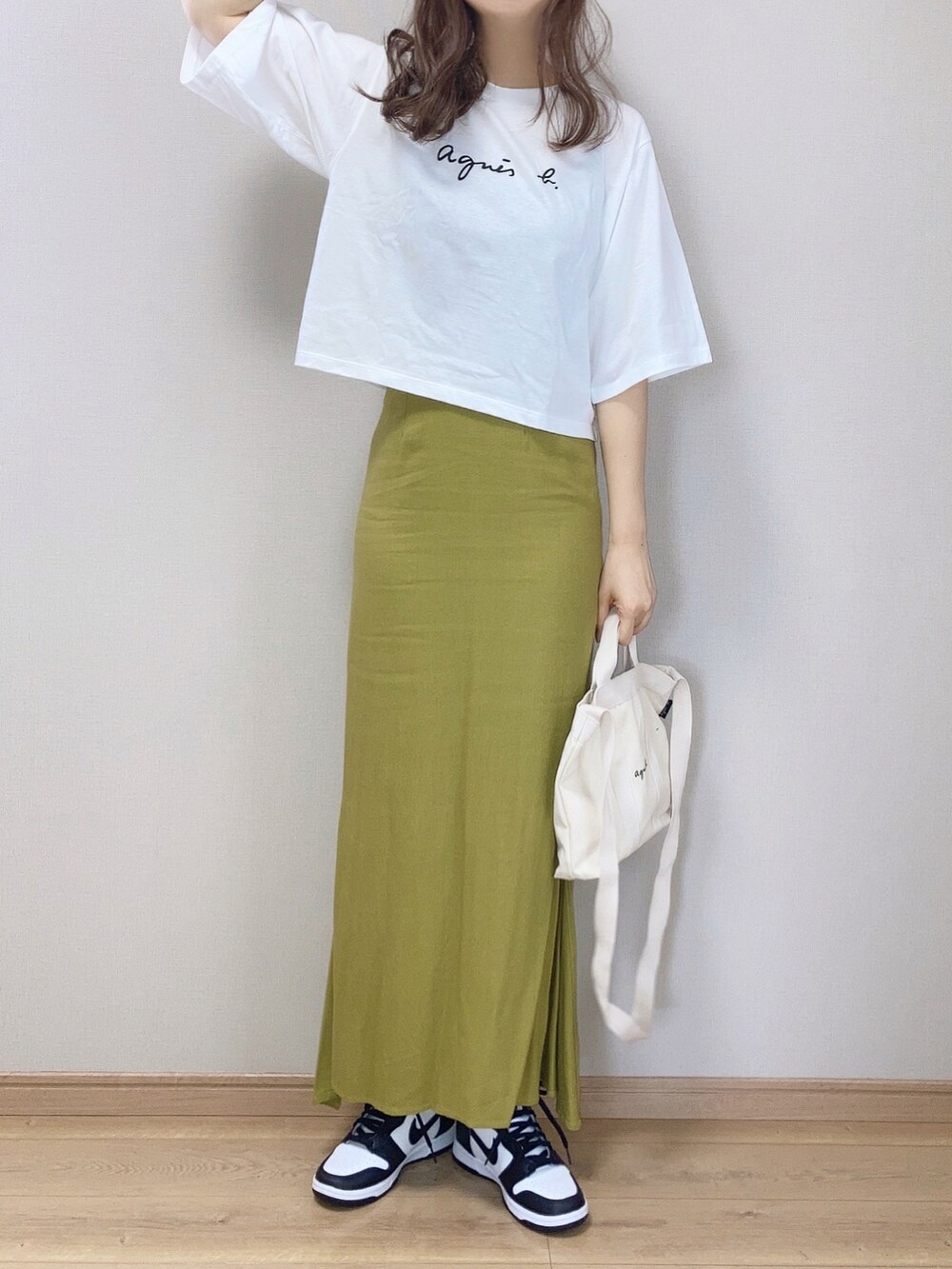 ホワイト系のTシャツ/カットソー、ホワイト系のトートバッグ、グリーン系のスカートを着用したレディースの春コーディネートの3枚目の写真