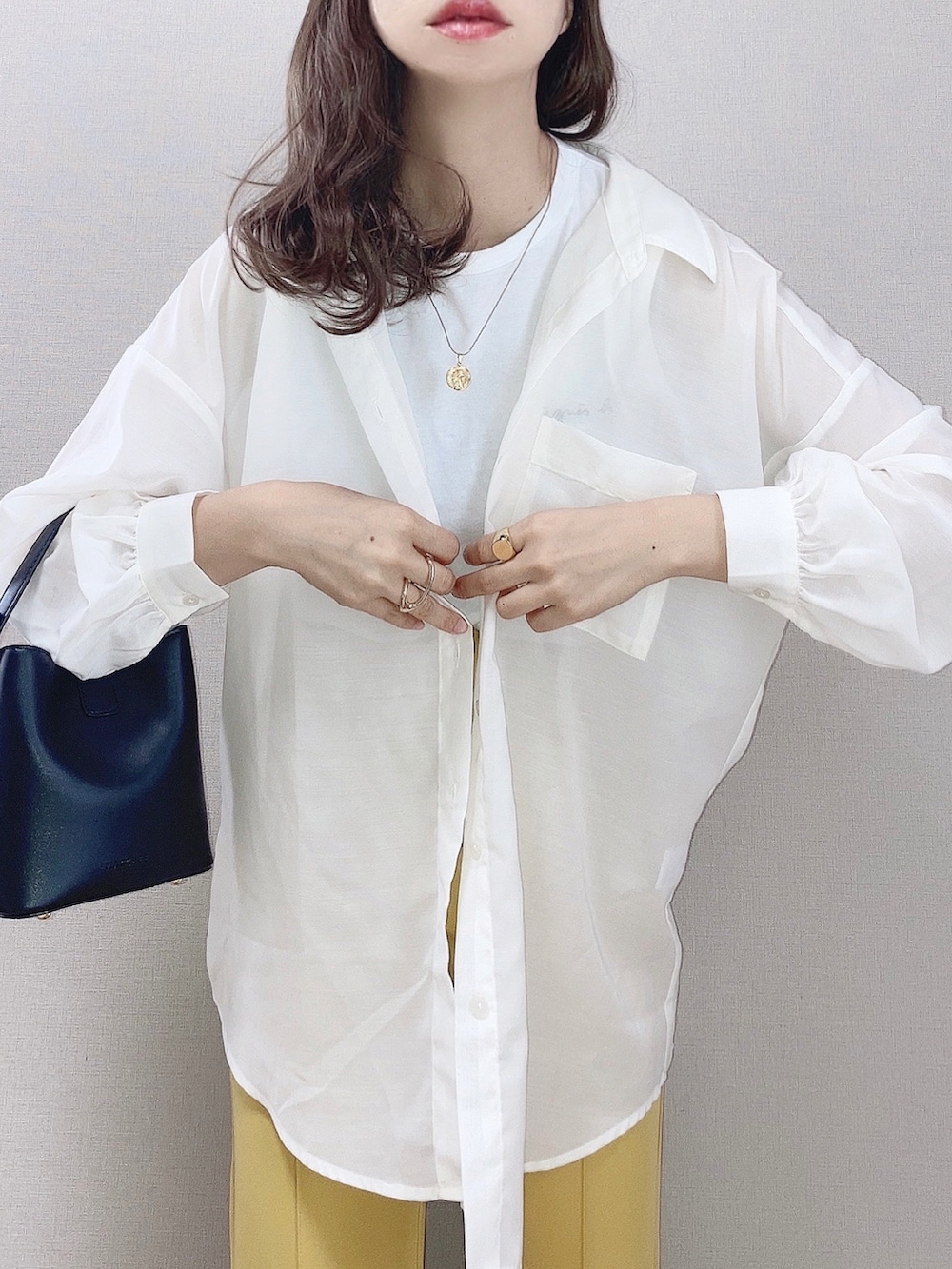 ホワイト系のシャツ/ブラウス、イエロー系のその他パンツ、ブラック系のサンダルを着用したレディースの春コーディネートの2枚目の写真