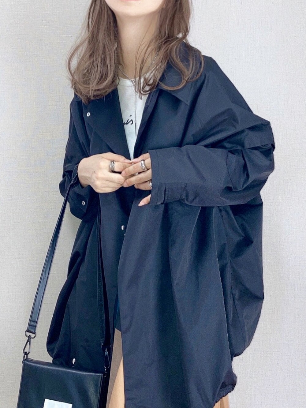 ブラック系のその他アウター、イエロー系のスカート、ブラック系のショルダーバッグを着用したレディースの秋コーディネートの2枚目の写真