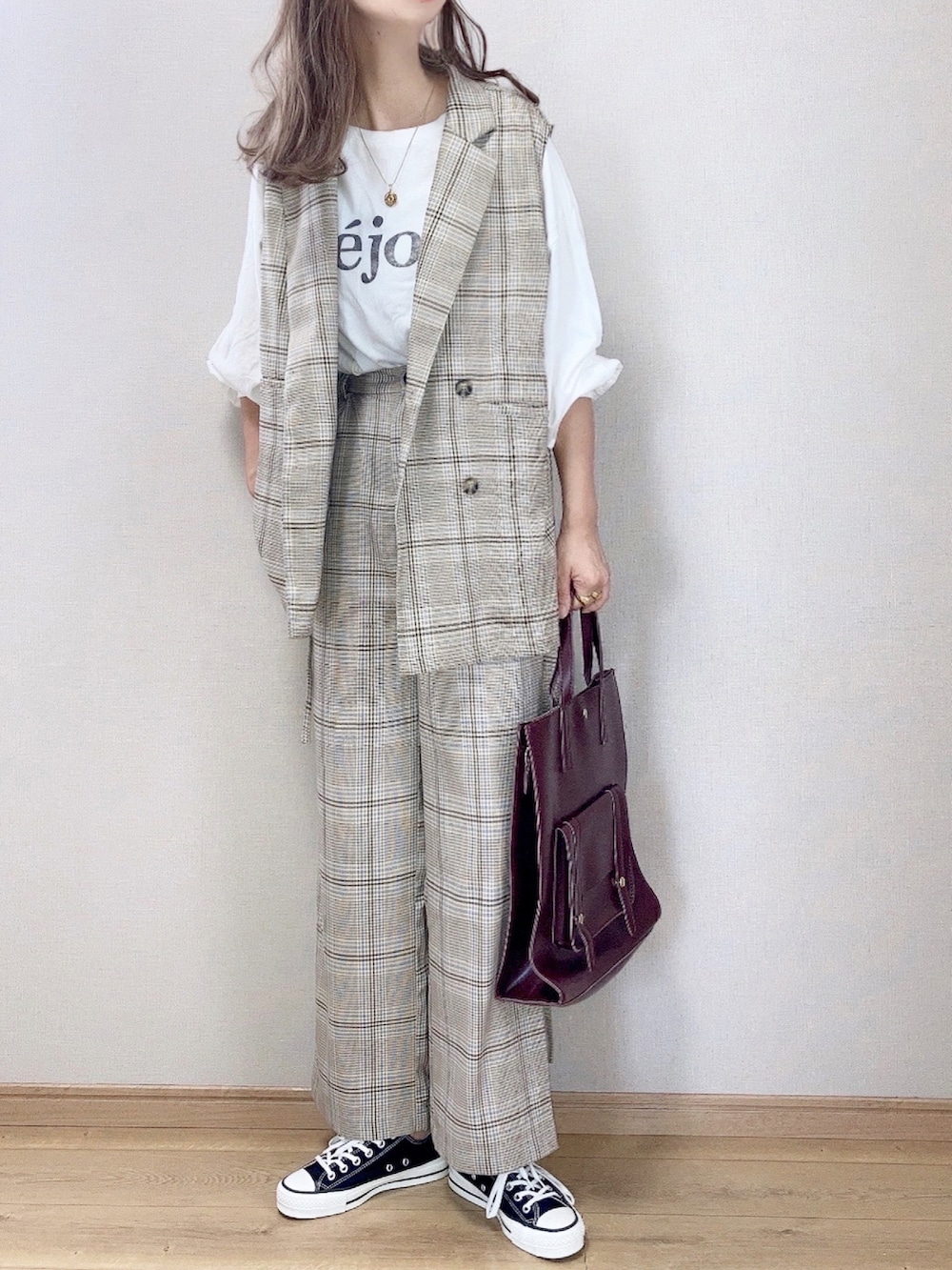 ベージュ系のベスト、ベージュ系のチノパンツ、ホワイト系のTシャツ/カットソーを着用したレディースの秋コーディネートの2枚目の写真