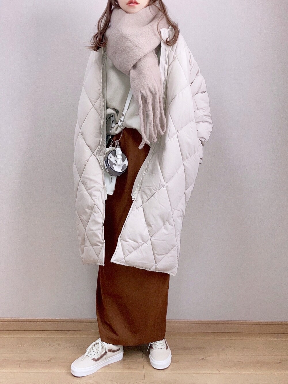ホワイト系のダウンジャケット/コート、ベージュ系のスウェット、ブラウン系のスカートを着用したレディースの冬コーディネートの2枚目の写真