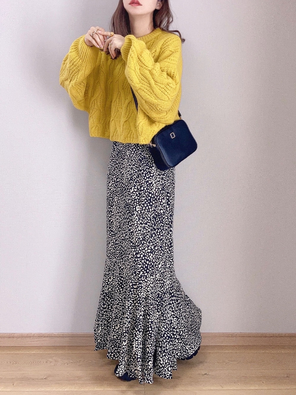 イエロー系のニット/セーター、ブラック系のスカート、ブラック系のドレスシューズを着用したレディースの秋コーディネートの2枚目の写真