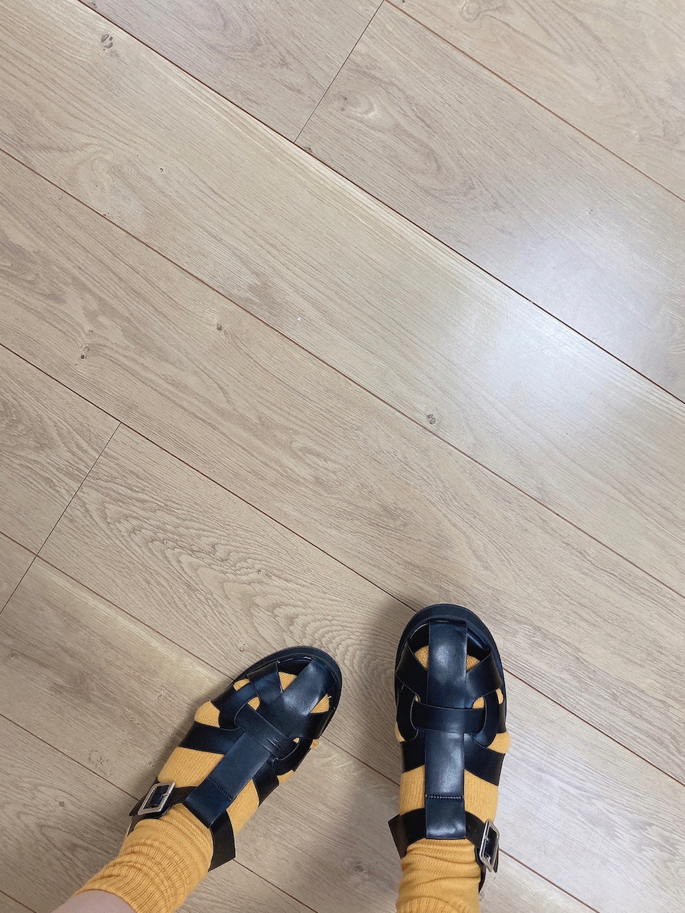 ブラック系のサンダル、ホワイト系のTシャツ/カットソー、ブラック系のスカートを着用したレディースの夏コーディネートの2枚目の写真