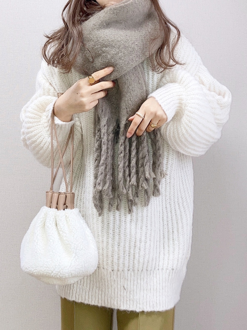 ホワイト系のカーディガン/ボレロ、ベージュ系のハンドバッグ、グリーン系のスラックスを着用したレディースの冬コーディネートの3枚目の写真