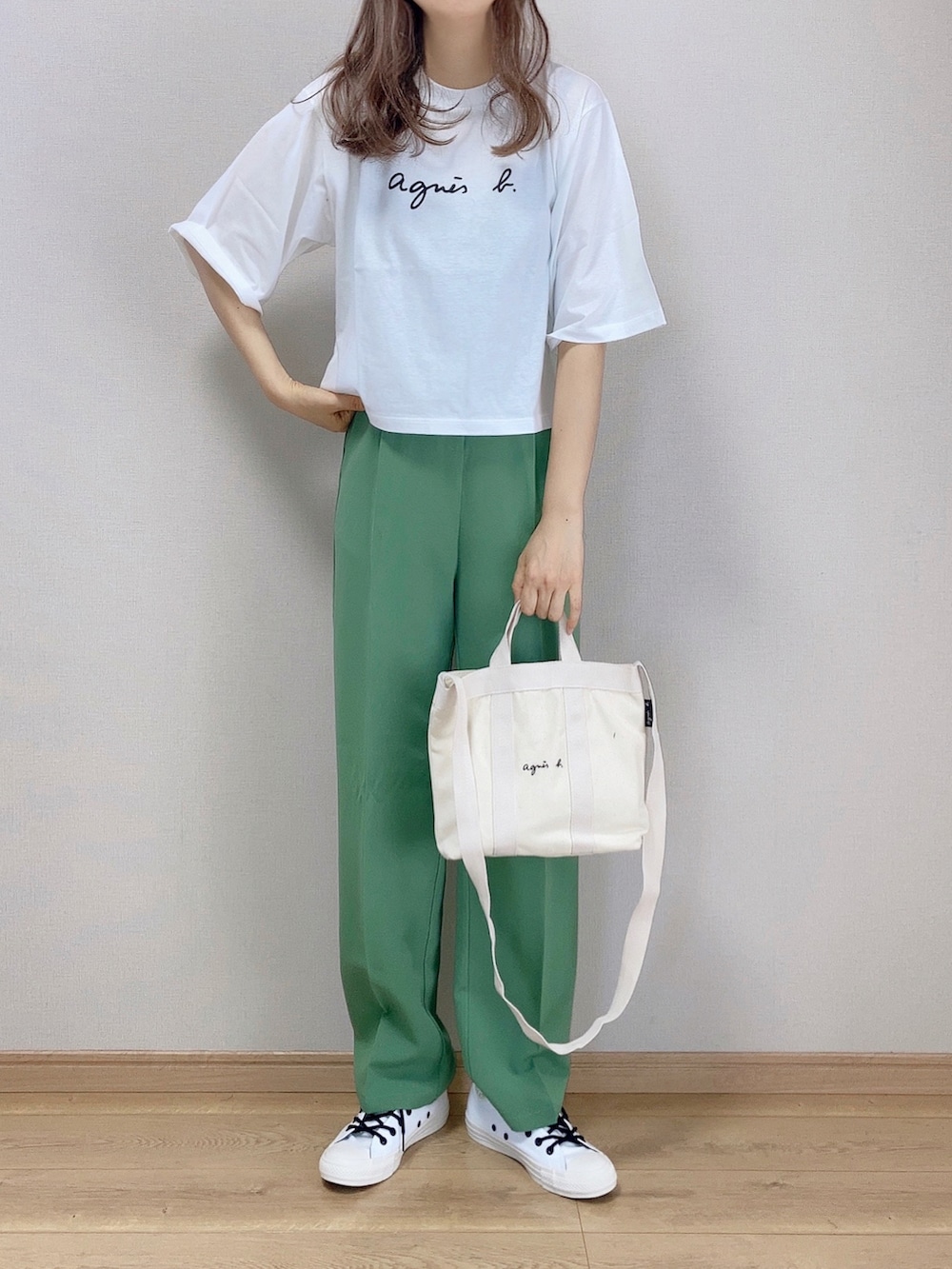 ホワイト系のTシャツ/カットソー、ホワイト系のトートバッグ、グリーン系のスラックスを着用したレディースの春コーディネートの2枚目の写真