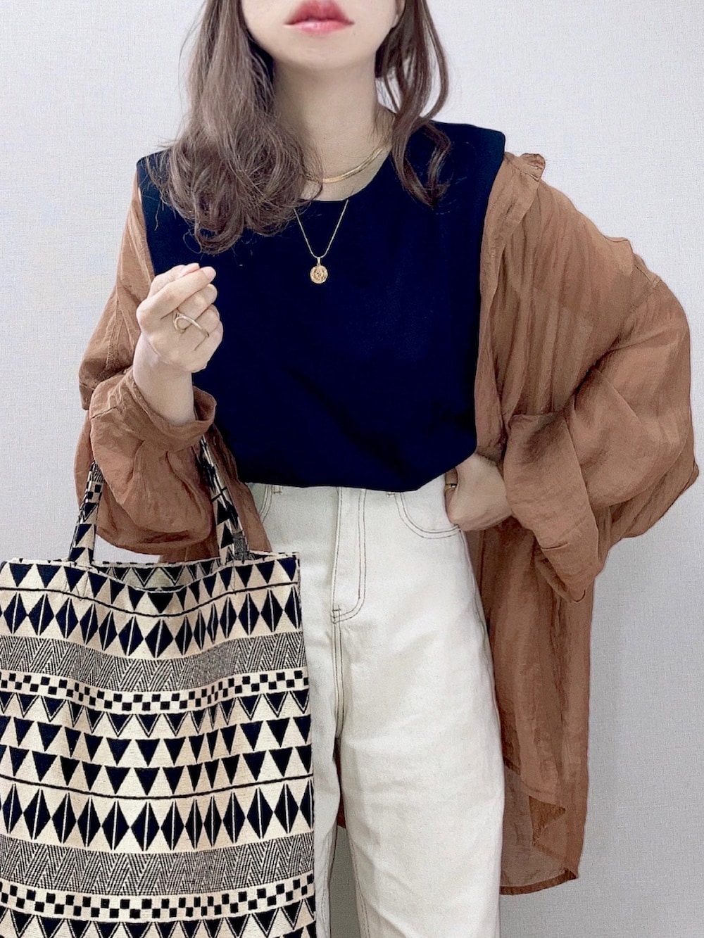 ブラウン系のシャツ/ブラウス、ブラック系のタンクトップ、ベージュ系のデニムパンツを着用したレディースの夏コーディネートの2枚目の写真