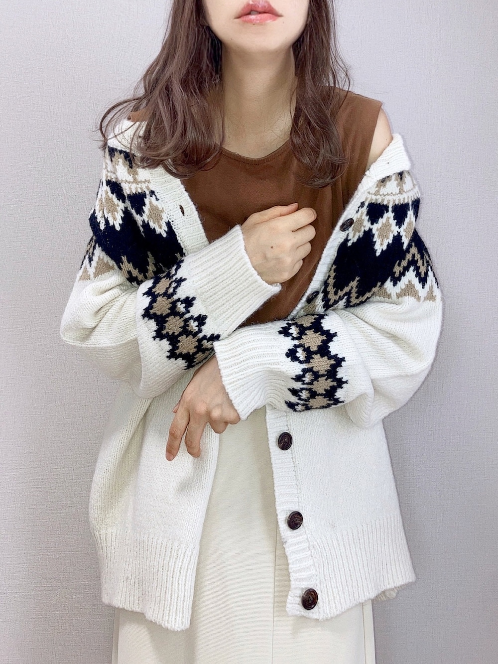 ホワイト系のニット/セーター、ホワイト系のスカート、ベージュ系のショルダーバッグを着用したレディースの秋コーディネートの2枚目の写真