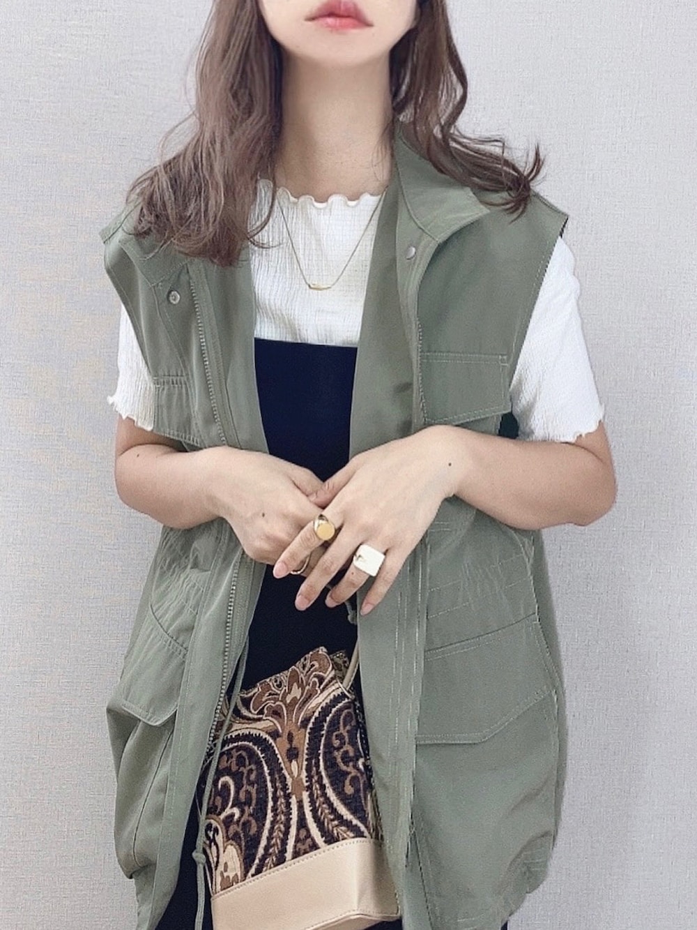 グリーン系のベスト、ホワイト系のTシャツ/カットソー、ブラック系のワンピースを着用したレディースの夏コーディネートの4枚目の写真